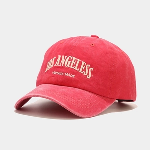 Detailed texture of red washed cotton baseball cap with Los Angeles vintage embroidery