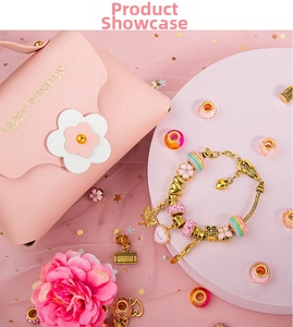 Pink DIY charm bracelet set with golden beads and a small pink leather gift bag