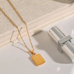 Detailed view of polished gold stainless steel chain with rectangular pendant
