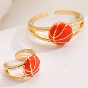 Λεπτομερής προβολή χρυσών ear cuffs με πορτοκαλί διακοσμητικά στοιχεία μπάσκετ