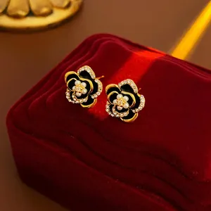 Vintage gold camellia flower stud earrings with crystals and micro pearls on velvet