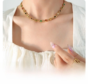 Close-up of 18K gold plated necklace featuring colorful inlaid zircon stones on a model