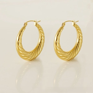 Close-up of 18K gold plated twisted rope hoop earrings with reflective metal finish