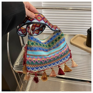 Detail of bohemian shoulder bag showing colorful woven patterns and tassel fringe accents