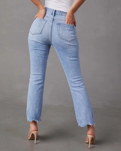 Dettaglio dei jeans a gamba dritta azzurri con orlo sfrangiato e trama denim lavato