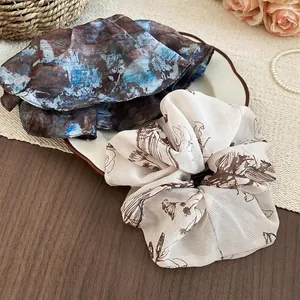 Vintage floral and marble pattern scrunchies on white tray for elegant hair styling
