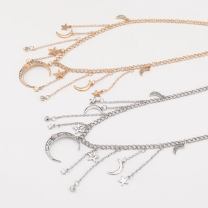 Detail of layered gold and silver moon and star necklaces with sparkling rhinestones
