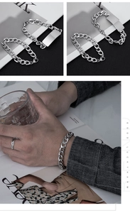 Detail of silver stainless steel Cuban link bracelet with secure clasp and ring set