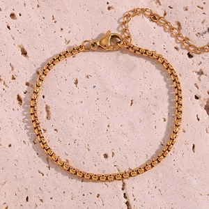 Detail of 18K gold-plated stainless steel box chain with lobster clasp on marble