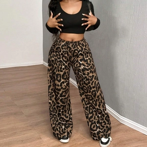 Dettaglio dei pantaloni larghi leopardati e crop top nero su una modella