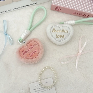Detail of plush heart keychains with Boundless Love embroidery and green rope accents