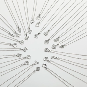 Polished silver alphabet initial pendant necklaces A-Z in radial layout on white background