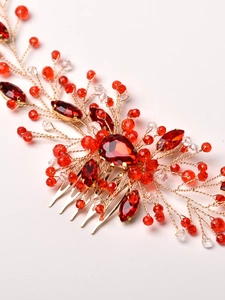 Macro detail of red crystals and gold wires on a handcrafted bridal hair comb