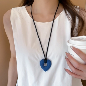 Blue heart pendant necklace with black cord worn by model for a minimalist daily look