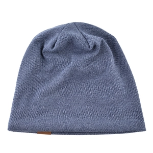 Navy blue knit beanie hat for men and women with brown leather label on plain background