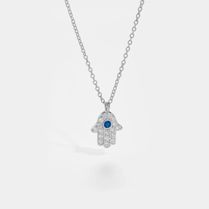 Macro shot of silver Hamsa Hand pendant with blue evil eye and sparkling zircons
