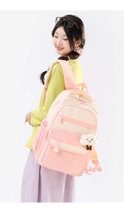 Detail view of pink and beige student backpack with cloud plush charm and padded straps