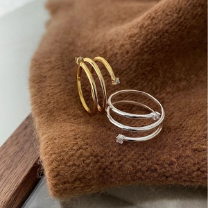 Detailed view of spiral triple-band silver rings in gold and silver with cubic zirconia