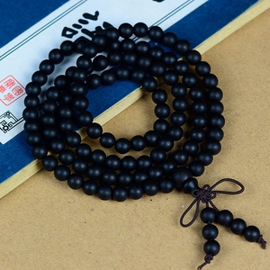 Détail de chapelet en bois noir mat avec nœud chinois traditionnel et deux glands