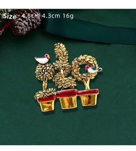 Detail view of bird plant pot brooch in gold enamel with dimensions 4.6cm x 4.3cm