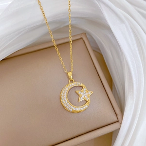Close-up of gold star and moon necklace with sparkling zircons on elegant silk