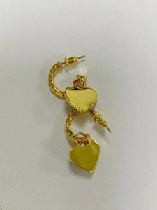 Dettaglio di orecchini a cuore in ottone placcato oro con design a spirale strutturato