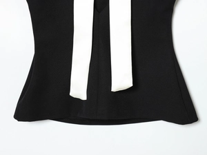 Détail rapproché du nœud contrasté noir et blanc sur ce haut décontracté pour femmes