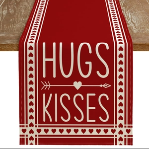 Detail of red Valentine's Day table runner with Hugs and Kisses prints on wood