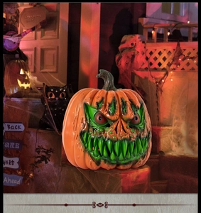 Detail of Halloween scary monster pumpkin lantern with sharp green teeth and red eyes