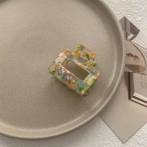 Dettaglio di un mollettone quadrato in acrilico con colorato motivo a terrazzo