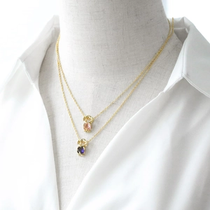 Double layered gold necklace featuring boy shape pendants with pink and purple zircon stones