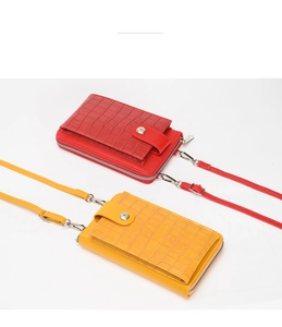 Detail view of red and yellow faux crocodile leather phone bags with magnetic clasps
