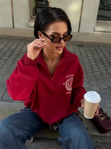 Detailaufnahme des dunkelroten Sweatshirts mit halbem Reißverschluss und Grafikdruck