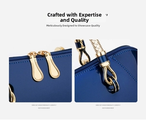 Detail of dark blue patent leather handbag featuring dual zippers and golden metal hardware