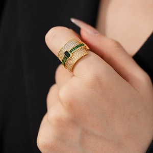 Detail of gold geometric ring featuring rectangular emerald zircon and micro-pave diamonds