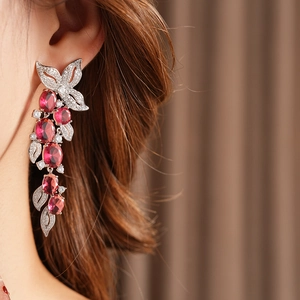 Détail de boucles d'oreilles pendantes avec pierres rouges et oxydes de zirconium
