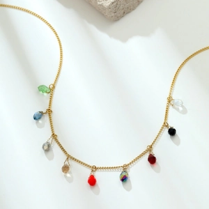 Detail view of gold chain necklace with multi-colored teardrop crystal pendants