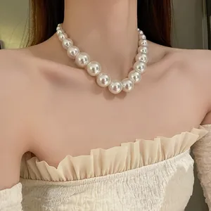 Primo piano di una collana di grandi perle barocche tonde color crema con finitura lucida