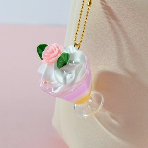 Pastel cream sundae keychain with pink rose and golden bead chain on pink background