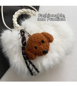 Close-up of white faux fur handbag with woven leather handle and brown teddy dog charm