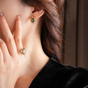 Set di gioielli placcati oro con orecchini e anello in zircone verde smeraldo su modella