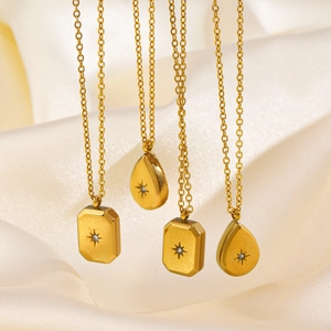 Gold stainless steel starburst necklaces with drop and square pendants on silk fabric