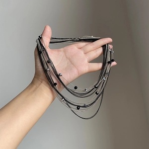 Dettaglio di una collana multistrato in metallo argento e nero con perle sfaccettate