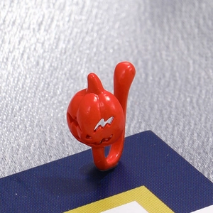 Detail of red pumpkin nose clip with hollow jack-o-lantern face and smooth lacquer finish