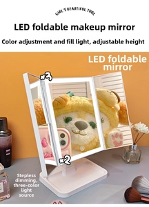 Detail of white tri-fold LED makeup mirror with 2x and 3x magnification and adjustable stand