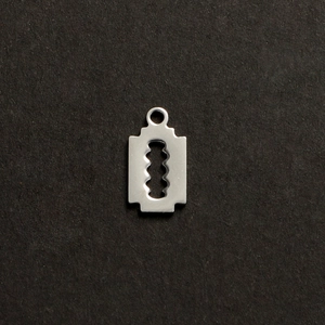 Detailed close-up of a silver stainless steel razor blade pendant on a dark background