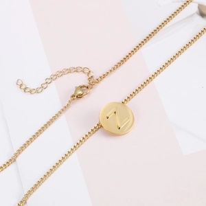 Macro shot of gold stainless steel necklace featuring a hollow letter Z round pendant