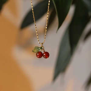 Elegant gold titanium steel necklace featuring a red carnelian cherry fruit pendant