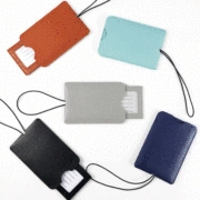 Detail of colorful PU leather luggage tags with pull-out cards and matching lanyards