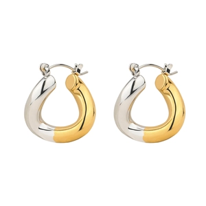 Detailed view of modern two-tone gold and silver circular stud earrings with metallic shine